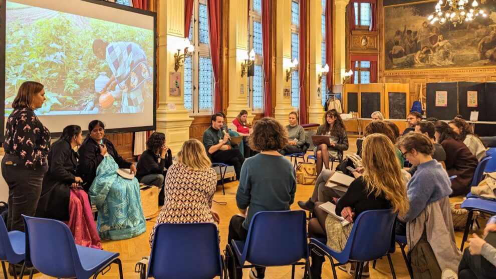 Un groupe d'adultes, assis en rond, échange et discute face à un écran