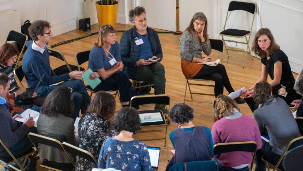 Un groupe d'adultes assis en cercle parle et écoute