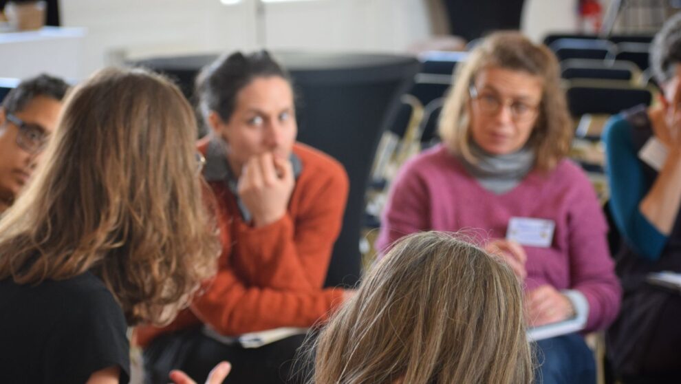 Un groupe d'adultes assis en cercle parle et écoute
