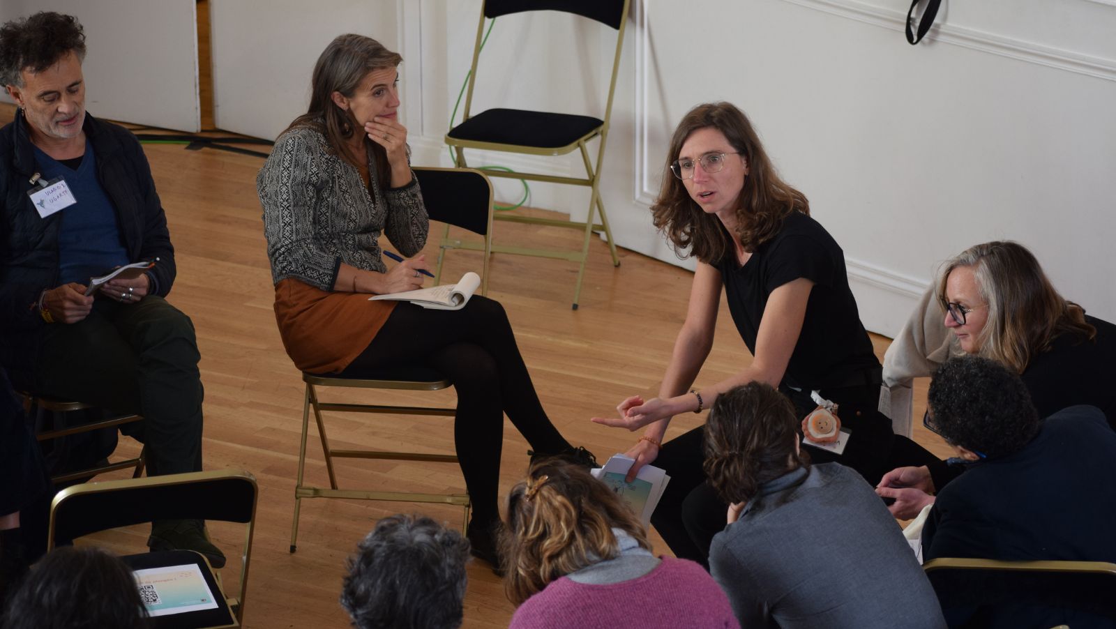 Un groupe d'adultes assis en cercle parle et écoute