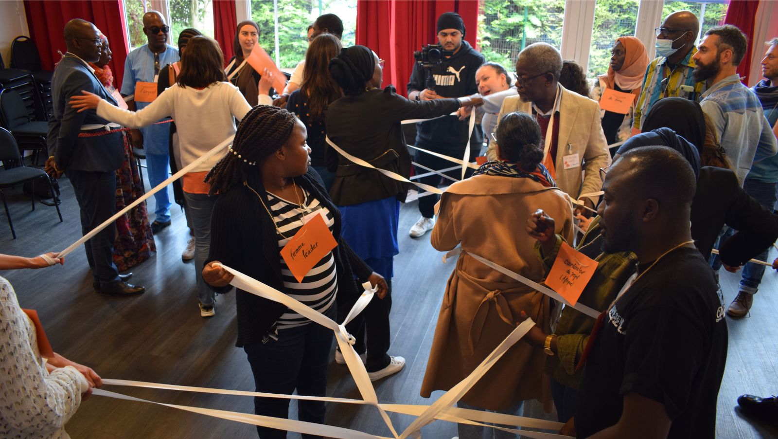 Un groupe d'adulte participe à un atelier interactif avec des rubans