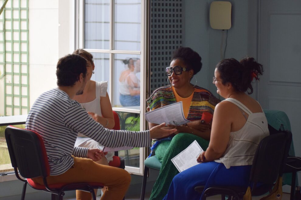 Un groupe d'adultes assis en cercle, discute en souriant