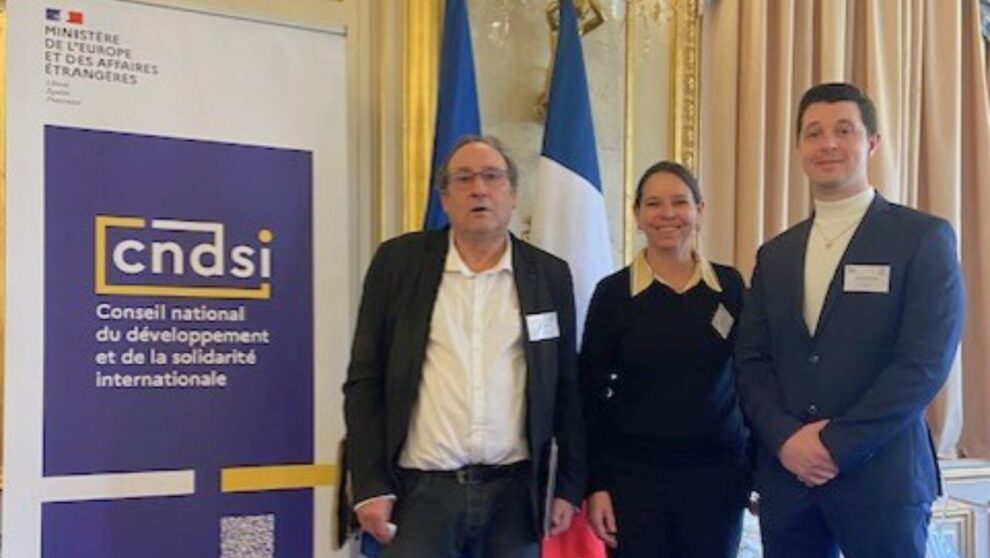 Directrice du F3E et cikkègue posant devant un kakemono du CNDSI