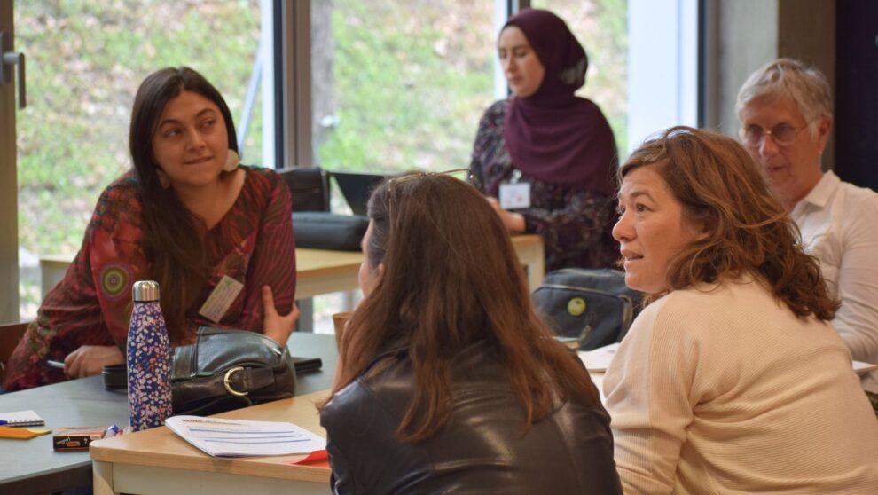 Groupe d'adultes assis autour d'une table et discutant ensemble
