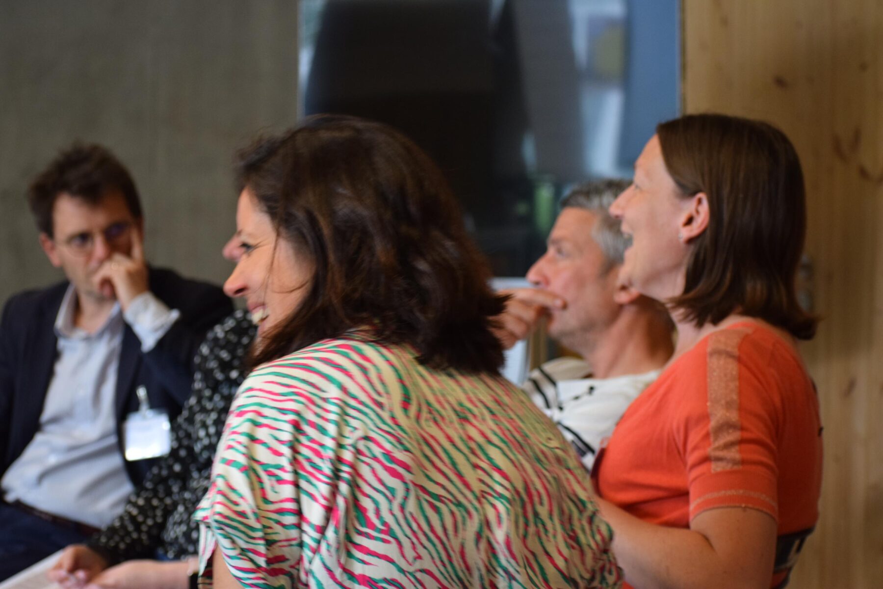 Groupe d'adultes assis en cercle riant ensemble