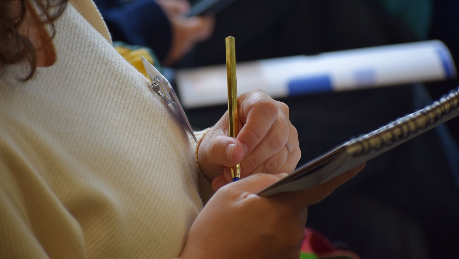 Gros plan montrant la main d'une adulte en train d'écrire sur un carnet