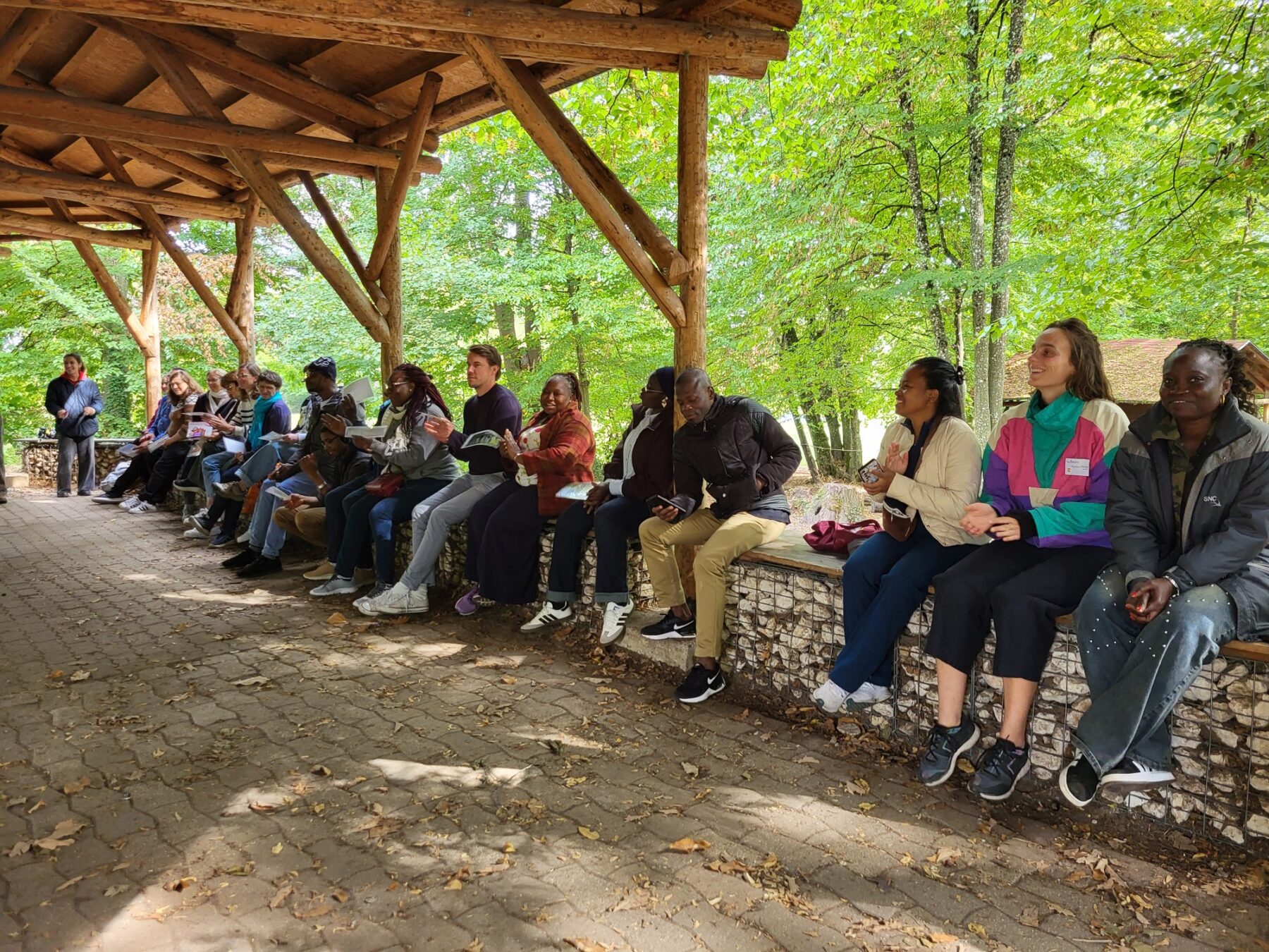 Un groupe d'adultes assis dehors, en milieu forestier