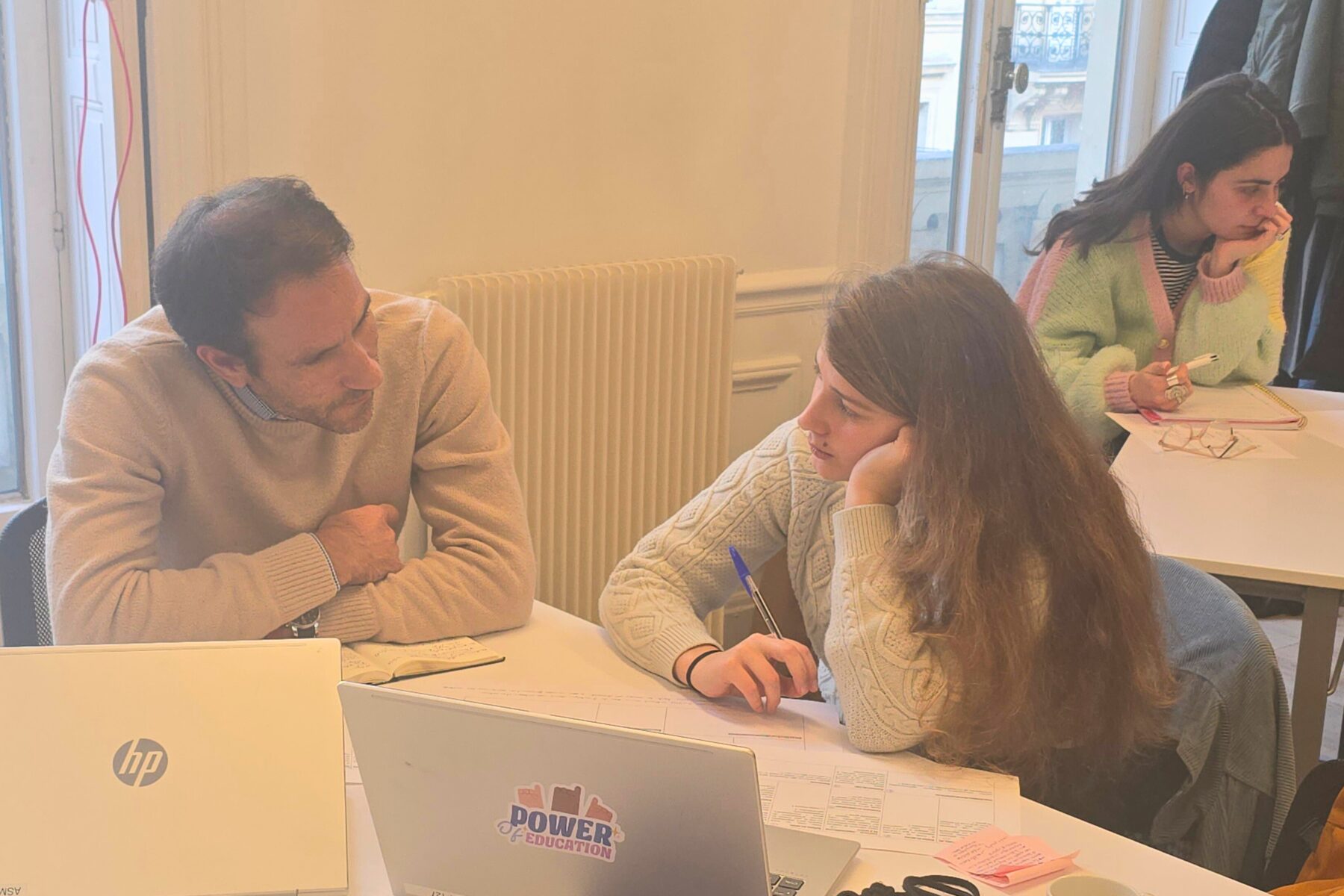 Deux adultes autour d'une table de travail parlent et échangent ensemble