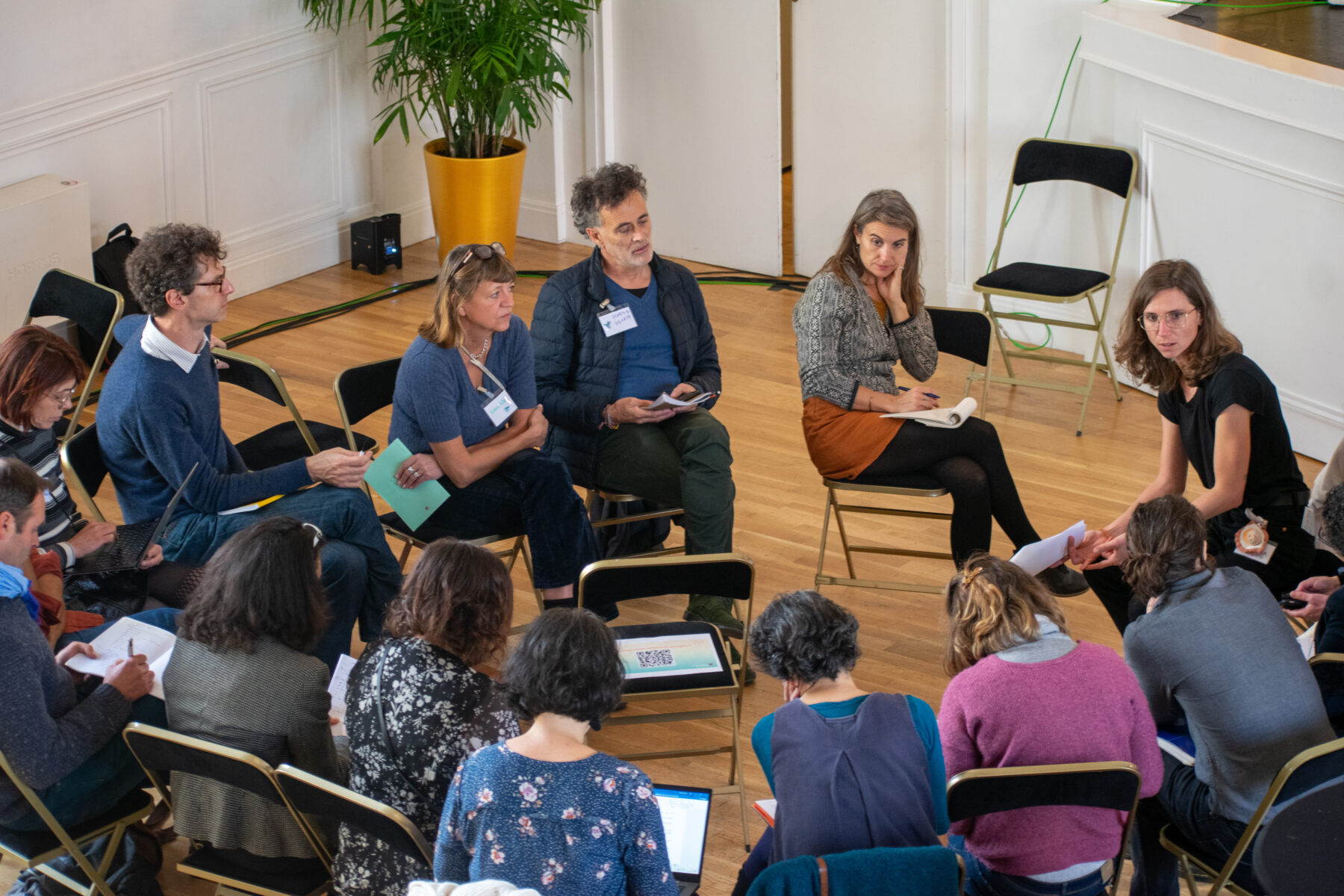 Groupe de parole avec plusieurs personnes assises sur des chaises en cercle et qui discutent entres elles