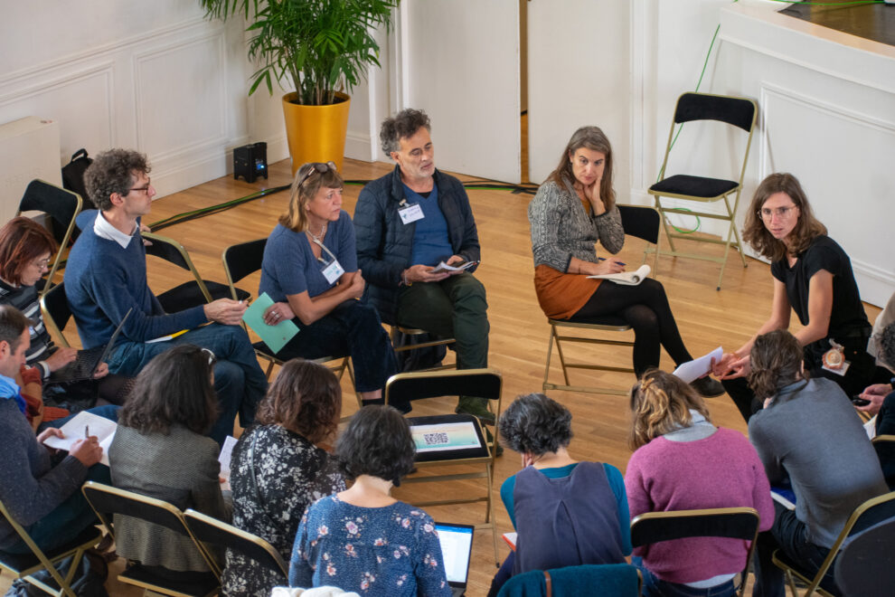 Groupe de parole avec plusieurs personnes assises sur des chaises en cercle et qui discutent entres elles