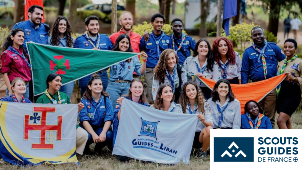 Groupe de scouts, avec différentes banderoles et drapeaux étendus devant eux