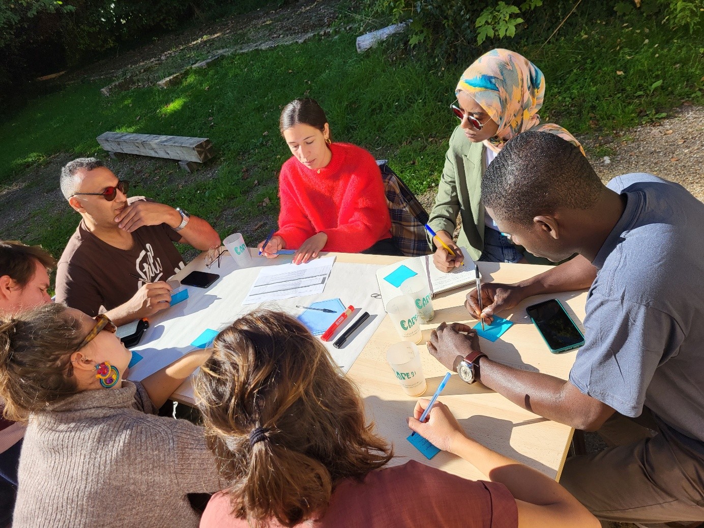 Groupe de sept personnes à une table, discutant 