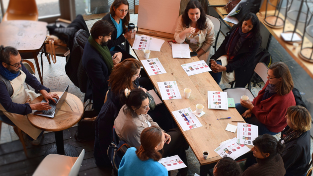 Un groupe d'adultes est assis autour d'une table et travaillent ensemble